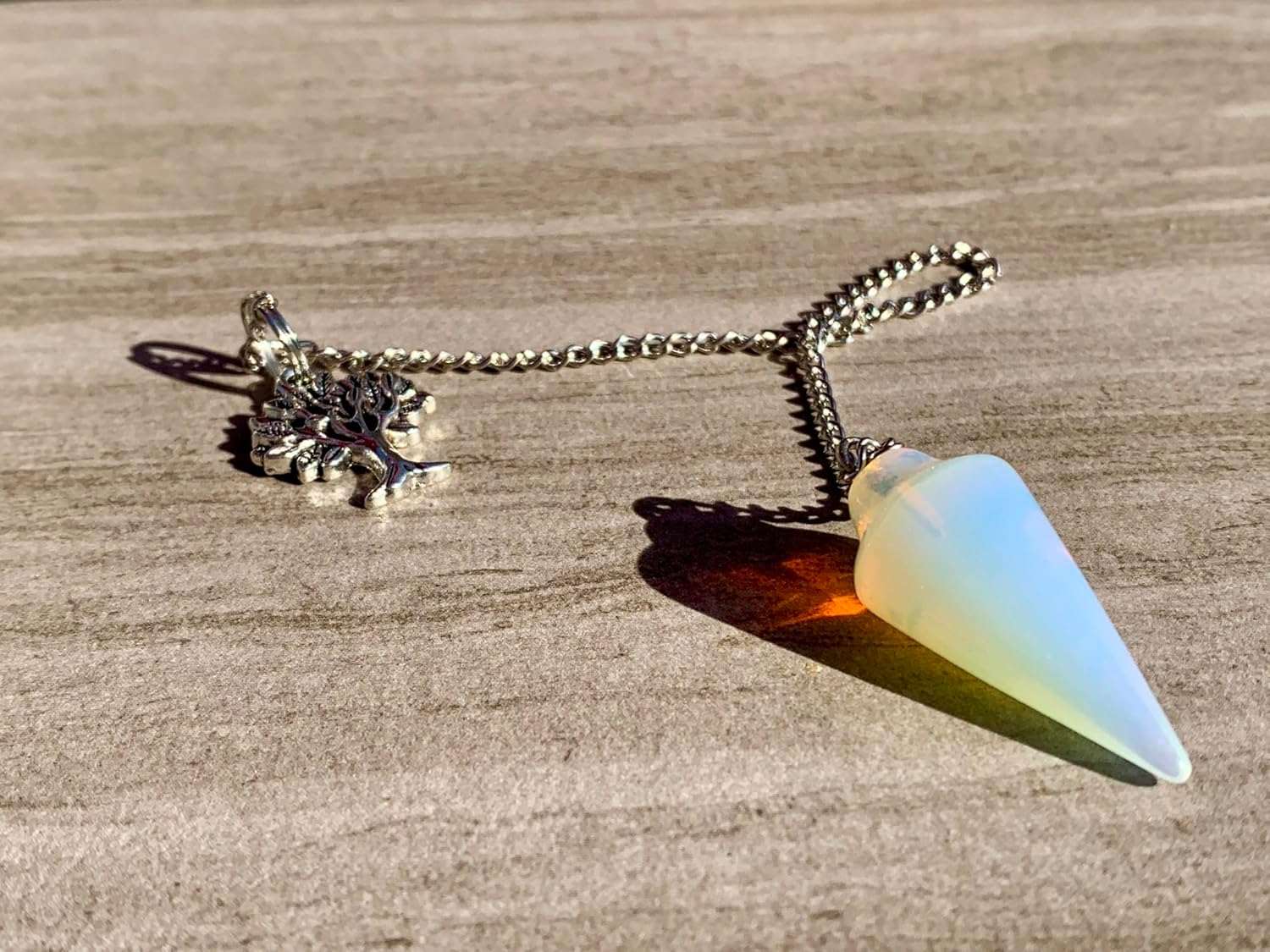 Opalite pendulum bag charm with tree charm and gold-tone chain, blue teardrop