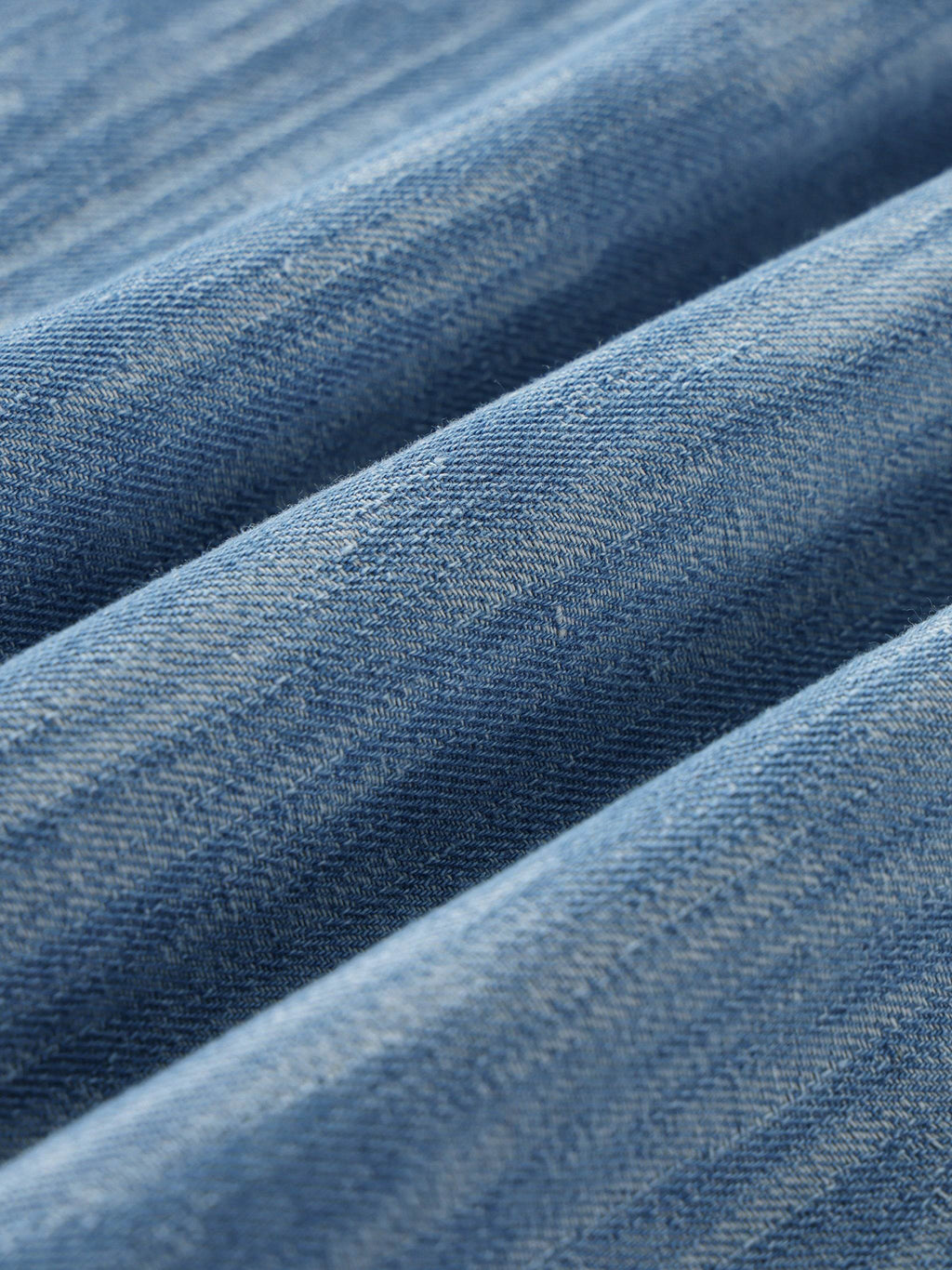 Blue distressed fabric close-up with visible woven texture and washed pattern