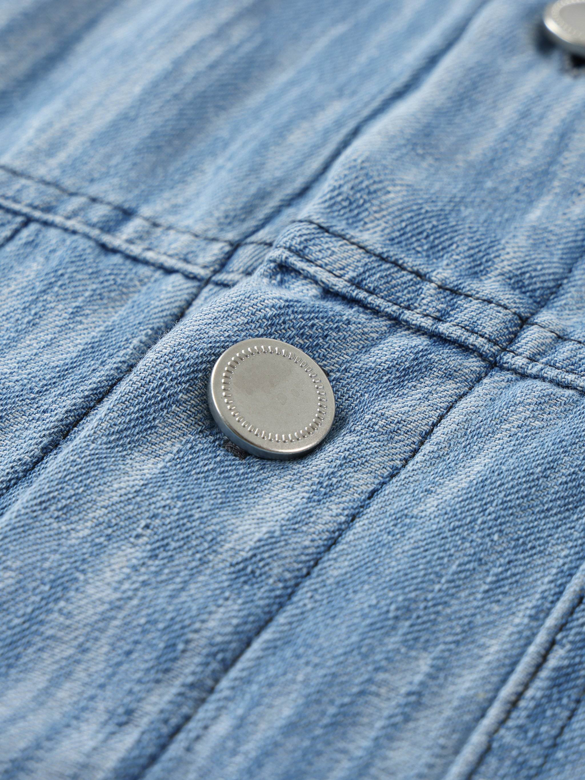 Blue distressed shirt close-up of metal button with cross-stitch placket