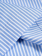 Blue-and-white vertical stripe shirt fabric close-up with curved seam