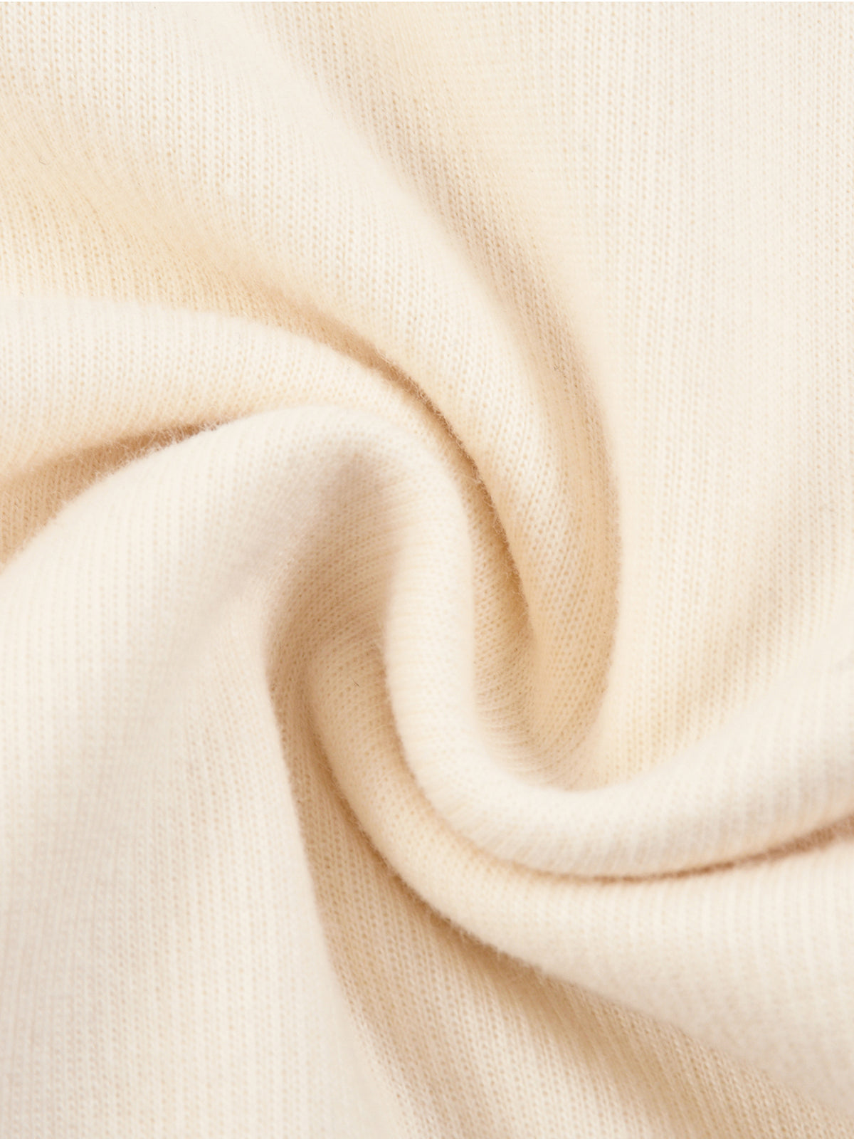 Cream knit fabric close-up with fine textured weave