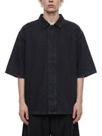 Black lyocell drop-shoulder button-up shirt with pointed collar, worn front view.