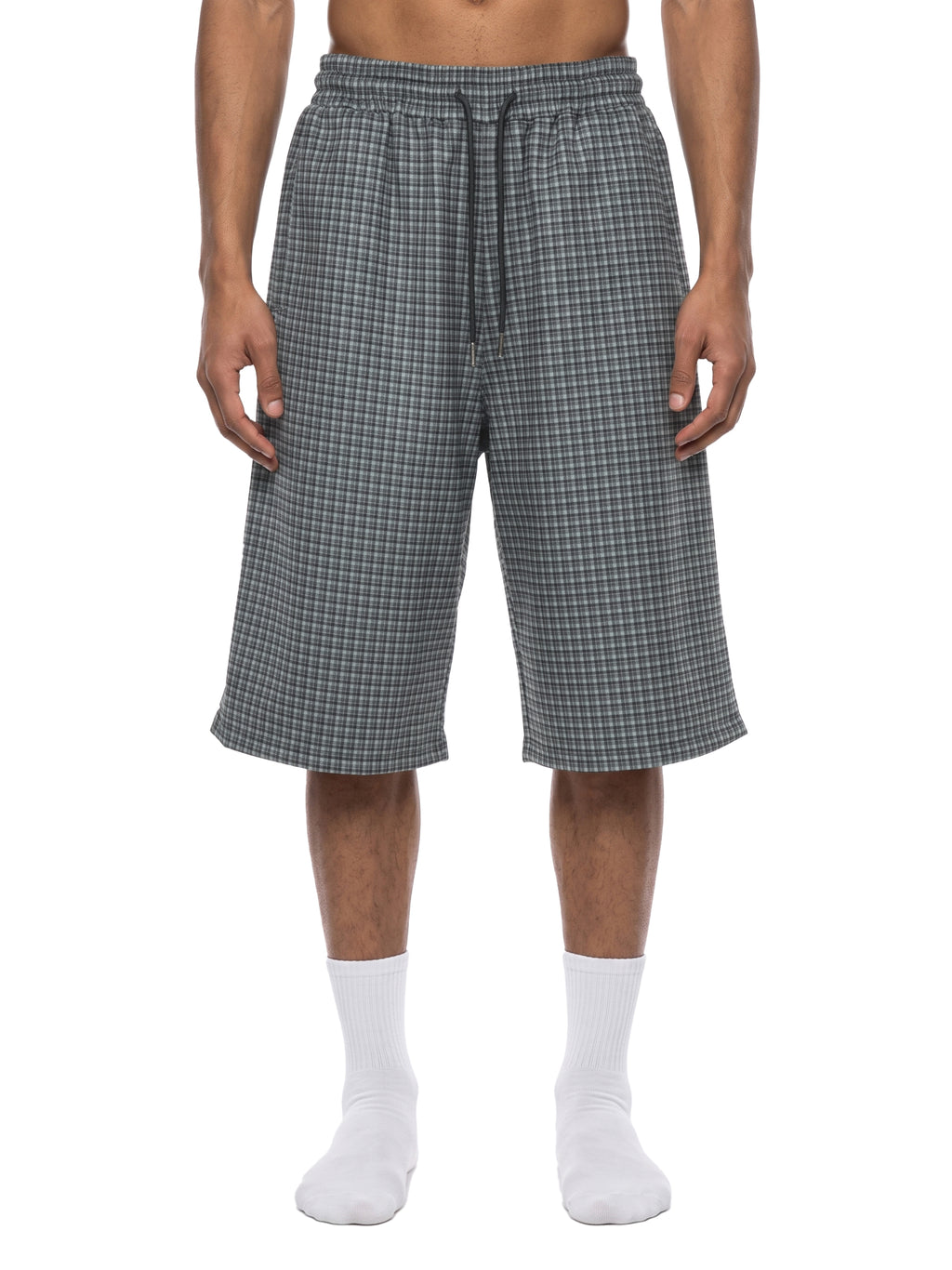 Navy blue plaid drawstring shorts on model, showing elastic waist and knee-length fit