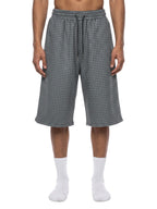Navy blue plaid drawstring shorts on model, showing elastic waist and knee-length fit