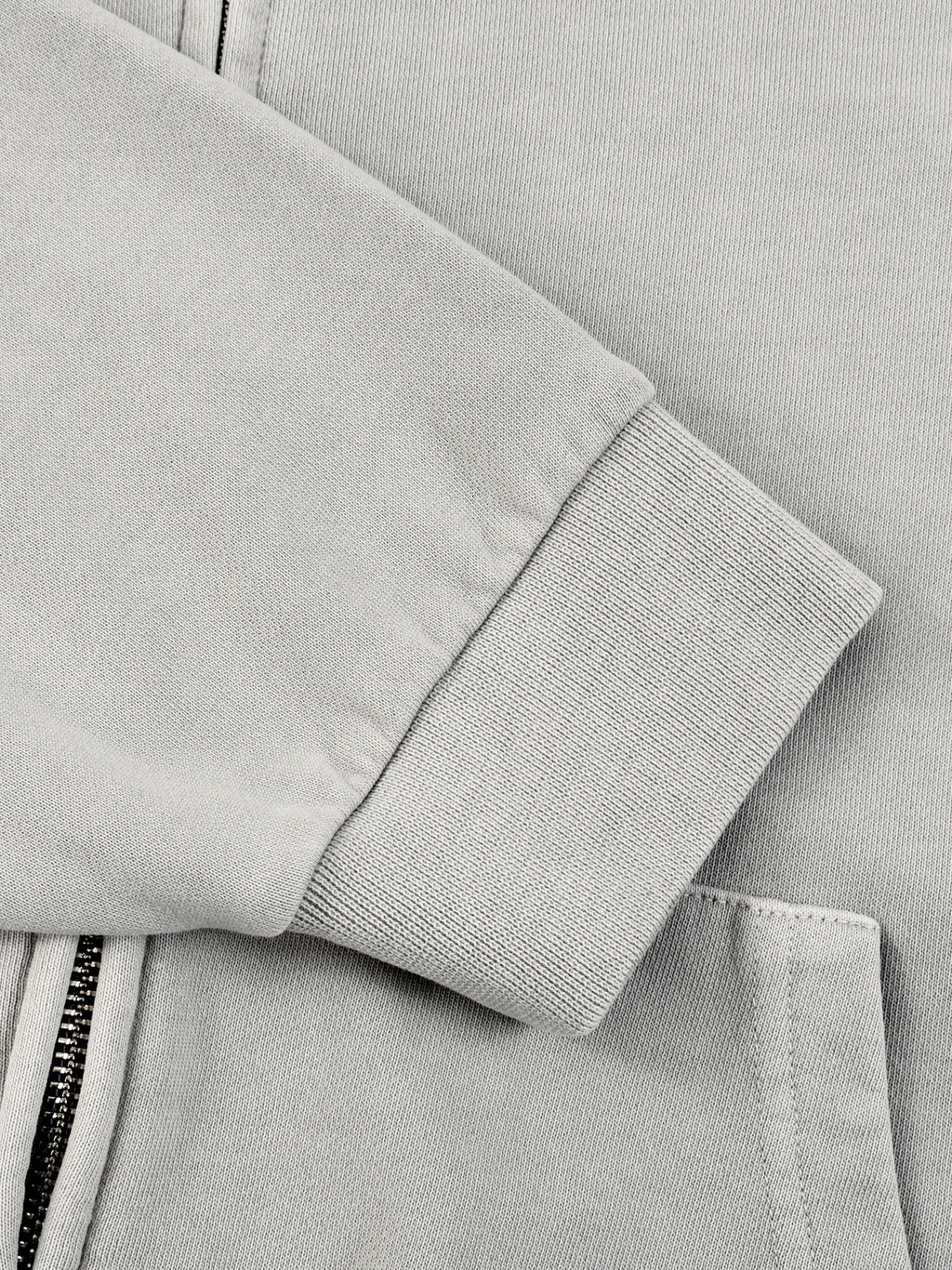Light gray hoodie sleeve with ribbed cuff and exposed zipper tape detail