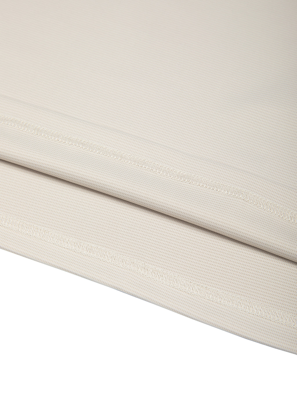 Lower hem seam detail on light beige color-block performance T-shirt