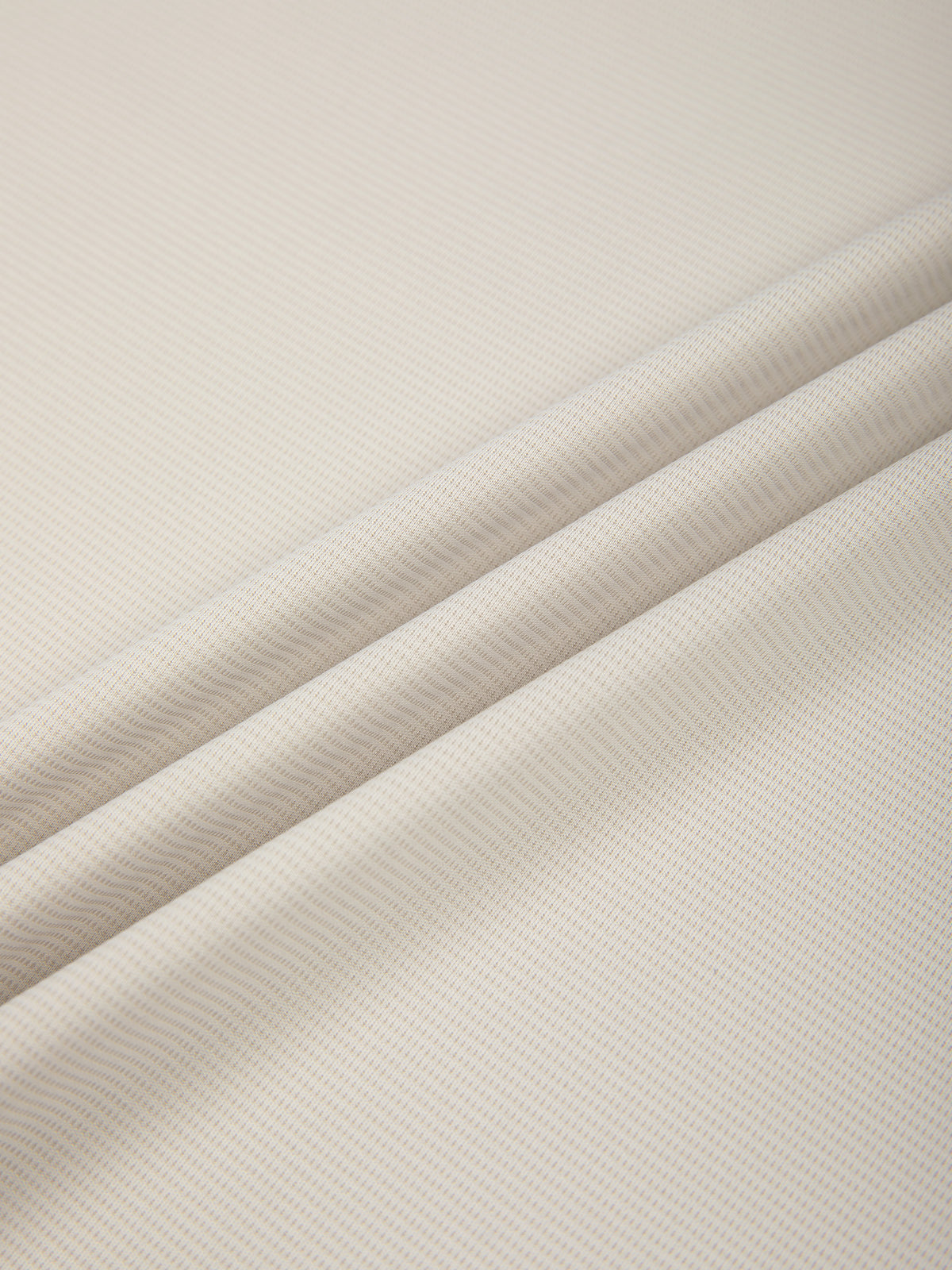 Fabric close-up of light beige performance T-shirt with fine textured knit