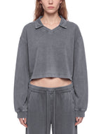 Model wearing a gray vintage wash crop sweatshirt with V-neck collar and long sleeves