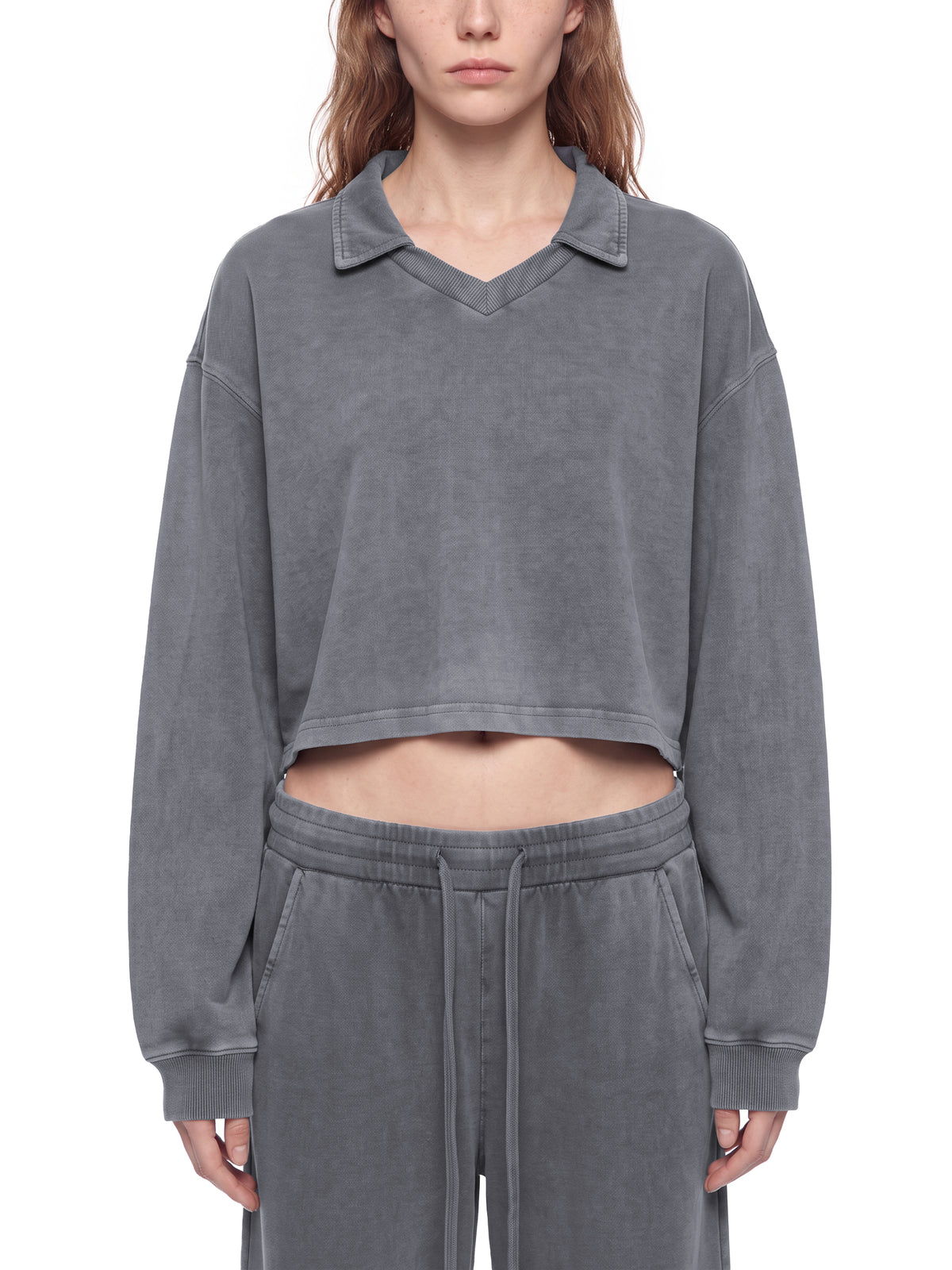 Model wearing a gray vintage wash crop sweatshirt with V-neck collar and long sleeves