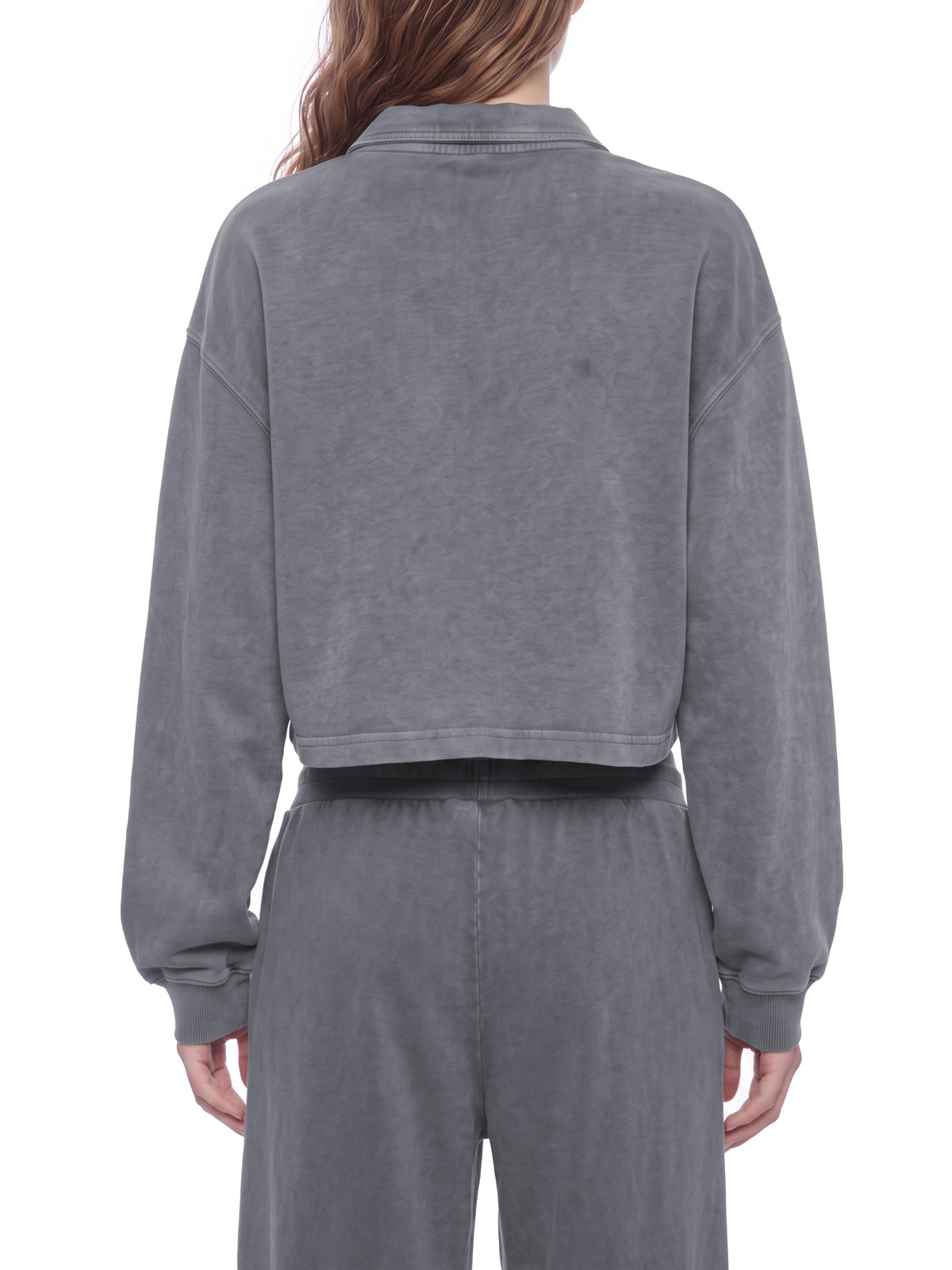 Model wearing a gray vintage wash crop sweatshirt, back view with ribbed cuffs