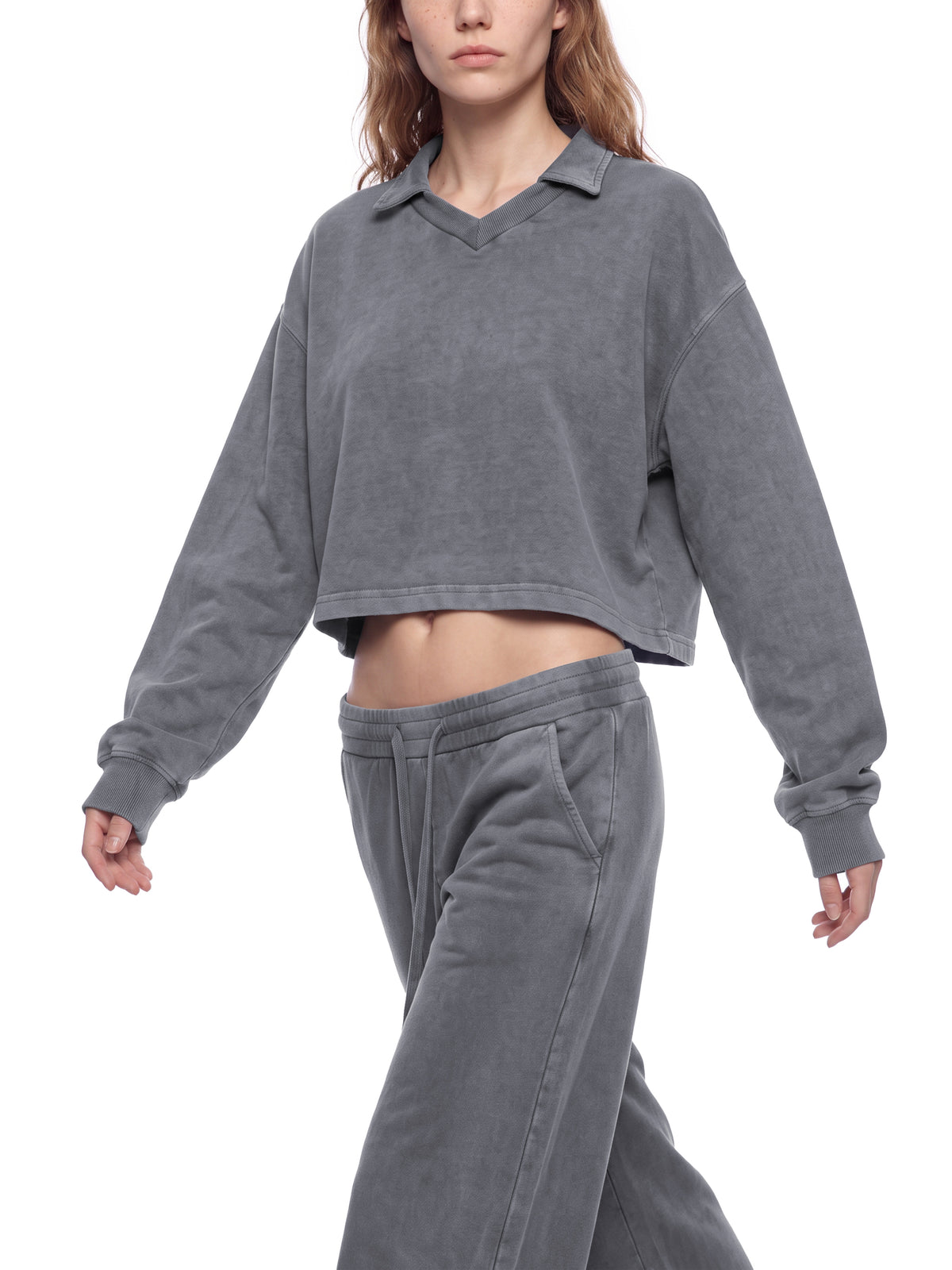 Model wearing a gray vintage wash crop sweatshirt with V-neck collar and long sleeves