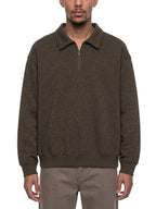 Unisex boxy quarter-zip sweatshirt in dark brown on model, collared quarter zip, ribbed hem
