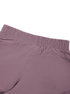 Women’s purple paneled yoga shorts front close-up with elastic waistband