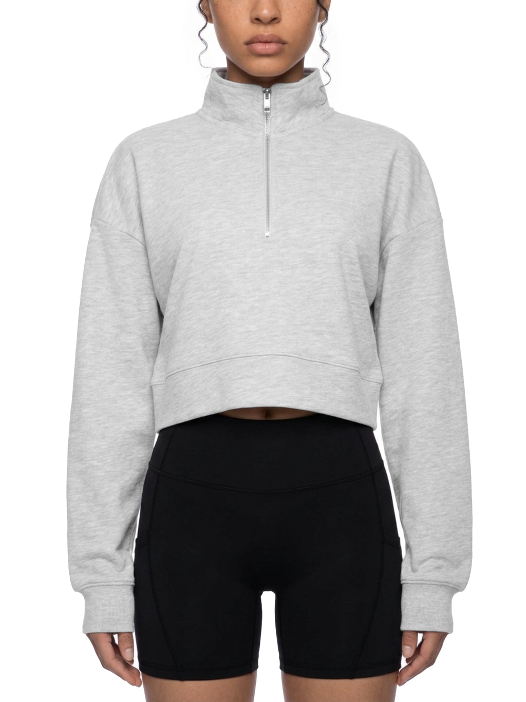 Light gray cropped quarter-zip sweatshirt worn with black bike shorts