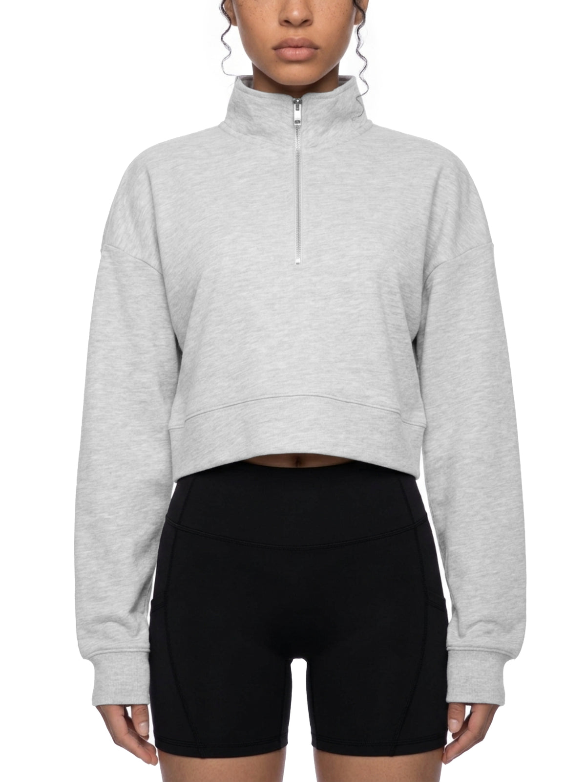 Light gray cropped quarter-zip sweatshirt worn with black bike shorts