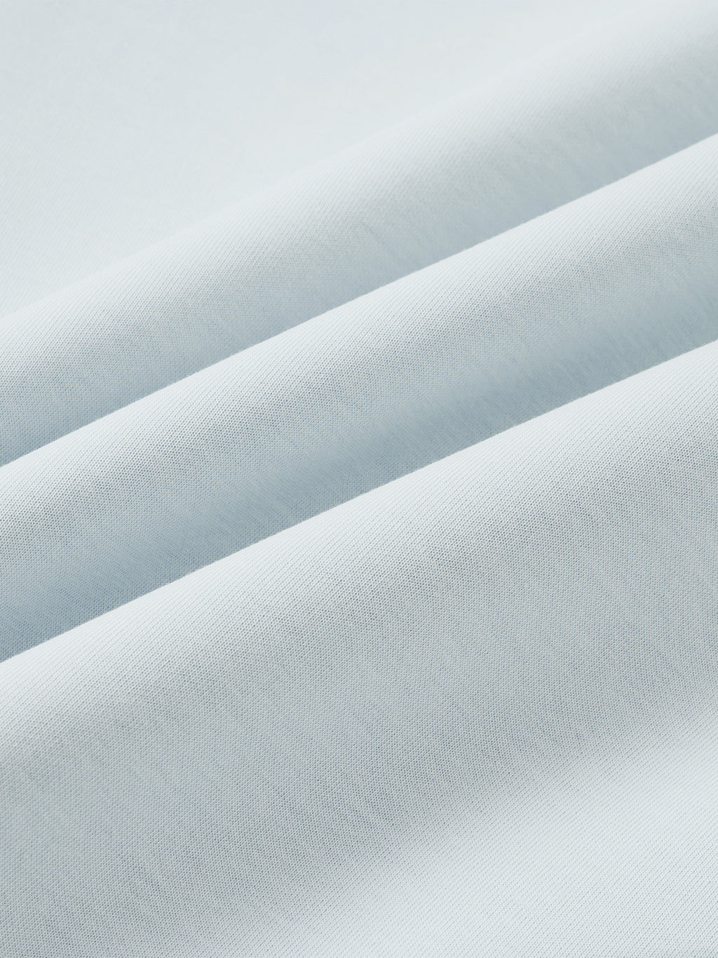 Light blue jacket fabric close-up with fine, smooth woven texture