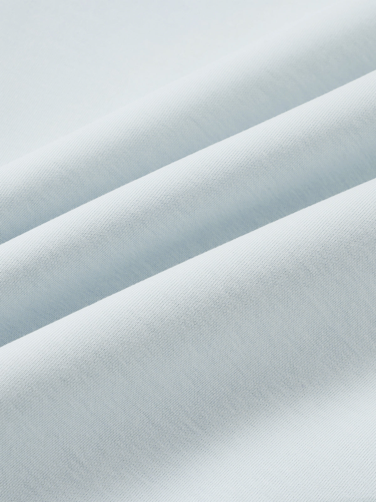 Light blue jacket fabric close-up with fine, smooth woven texture