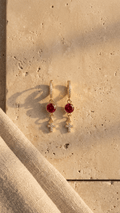 Gold-tone cross drop earrings with round red gemstones and small zircon accents