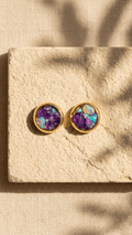 Gold opal stud earrings with purple gemstone center and iridescent bezel