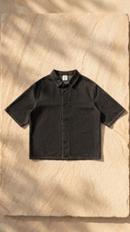 Black unisex drop-shoulder lyocell shirt with short sleeves and button-front, front view