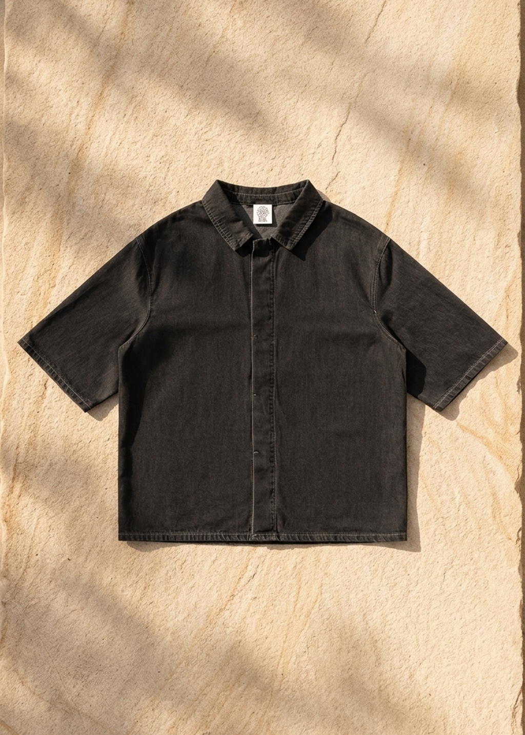 Black vintage-wash lyocell short-sleeve shirt, drop-shoulder button-front, flat lay