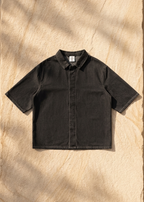 Black vintage-wash lyocell short-sleeve shirt, drop-shoulder button-front, flat lay
