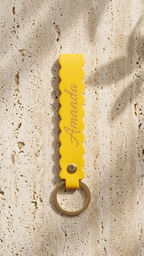 Yellow scallop-edge leatherette keychain with round key ring and engraved script