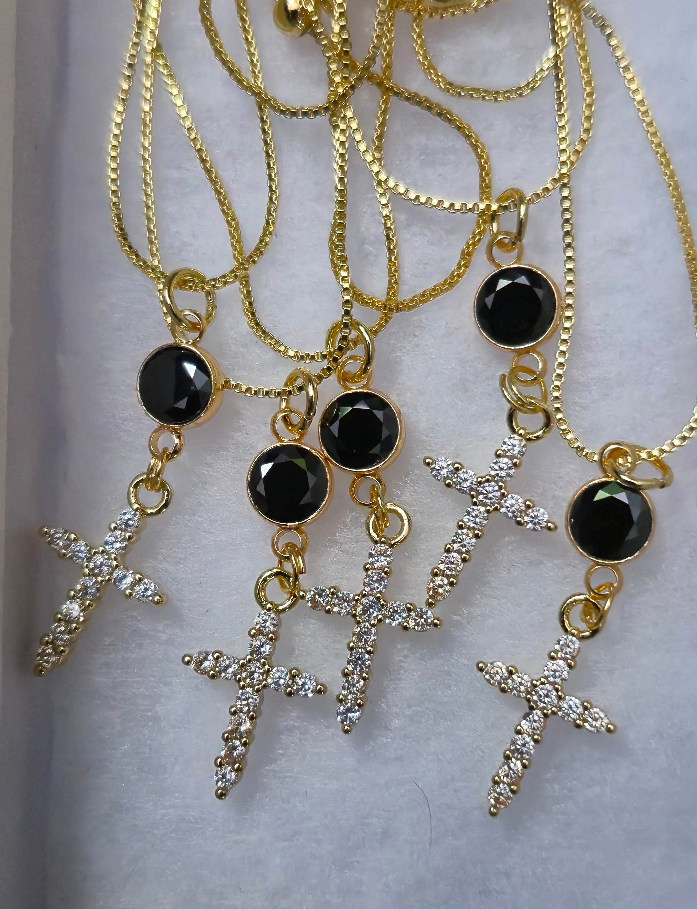 Set of gold-tone cross pendant necklaces with black round stones and crystal crosses