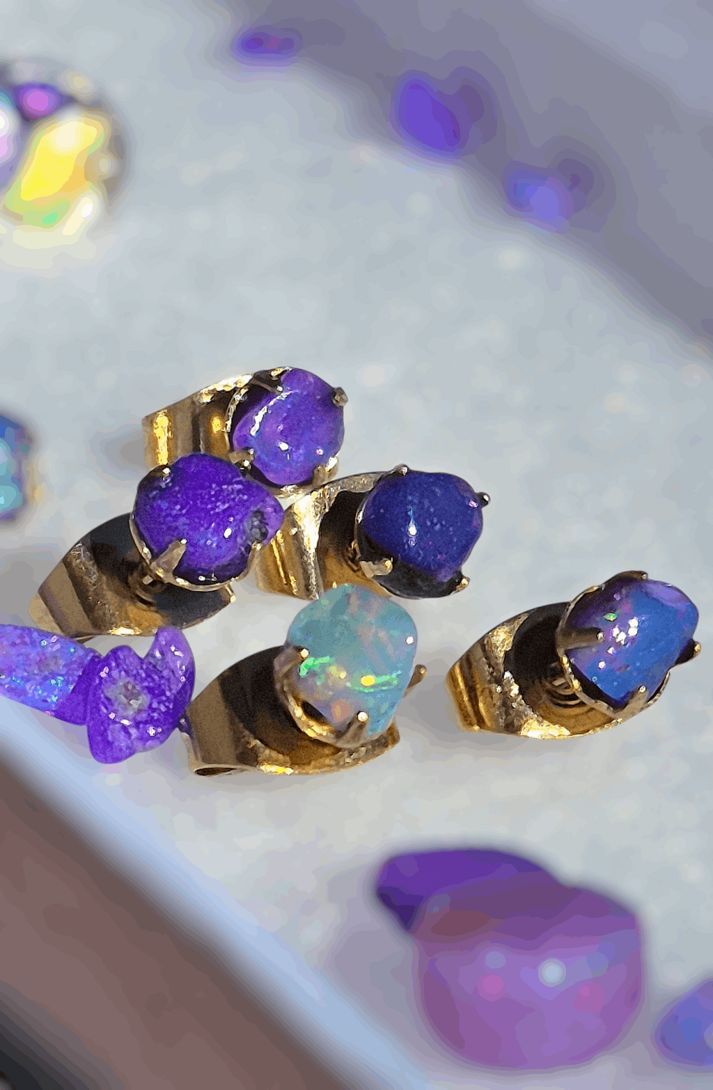 Gold opal chip stud earrings with purple and blue opal chips in gold bezel settings