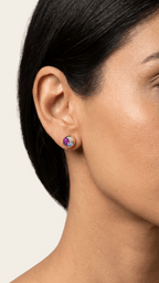 Purple opal stud earrings on ear with small iridescent round gemstone