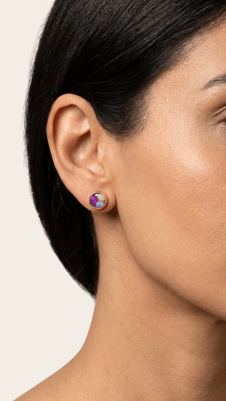 Purple opal stud earrings on ear with small iridescent round gemstone