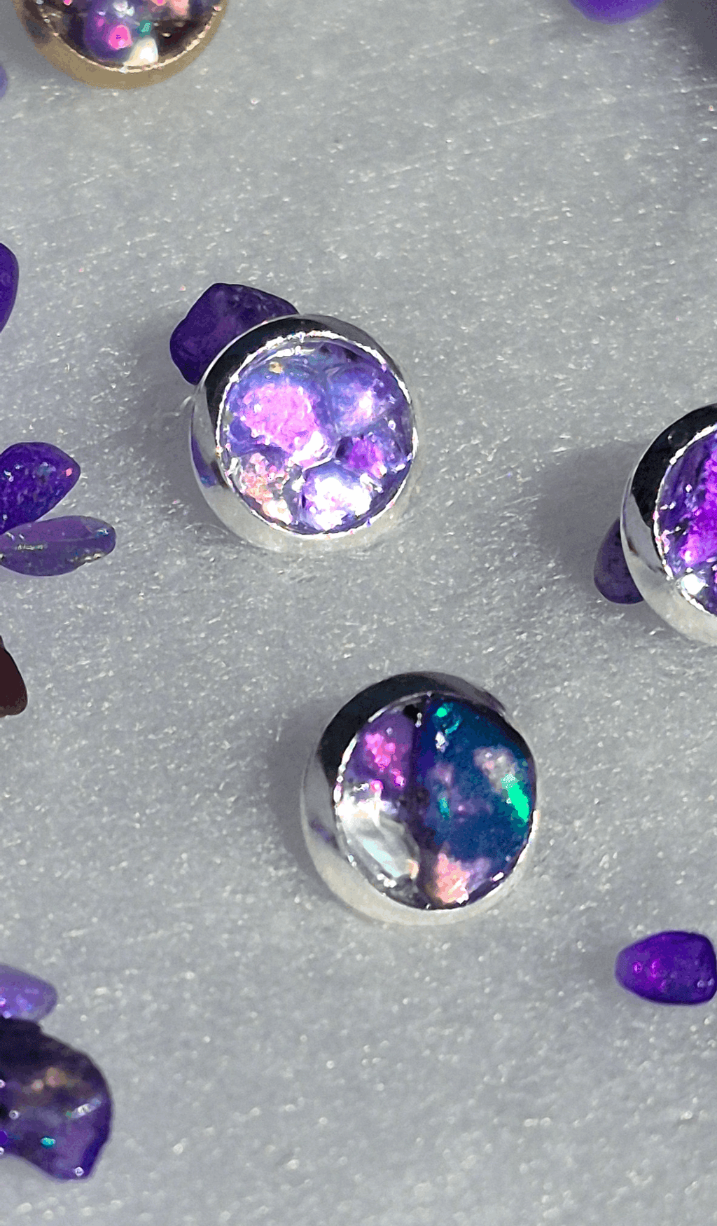 Silver stud earrings with round-oval purple opal and iridescent rainbow flecks