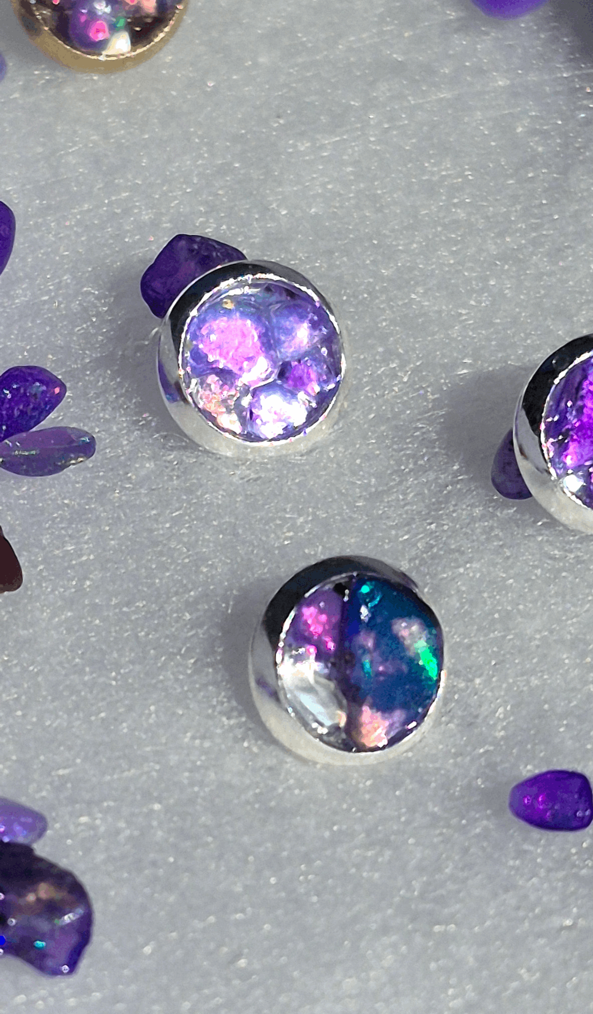 Silver stud earrings with round-oval purple opal and iridescent rainbow flecks
