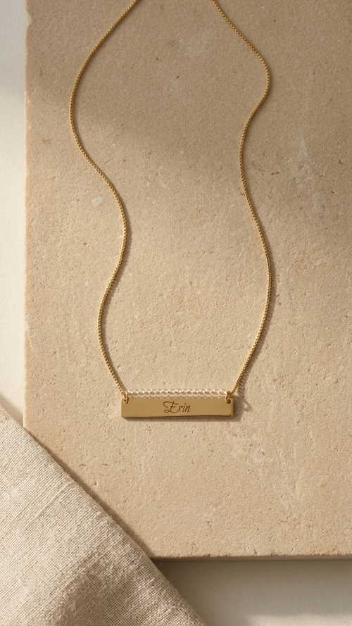 Gold beaded bar name necklace with engraved rectangular pendant on a fine chain