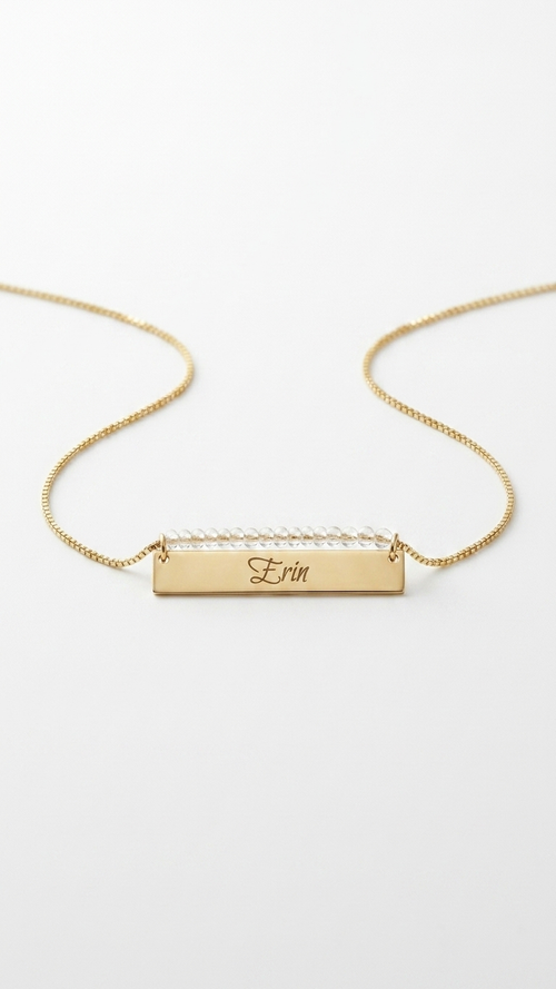 Gold beaded bar name necklace with engraved rectangular nameplate on a short chain
