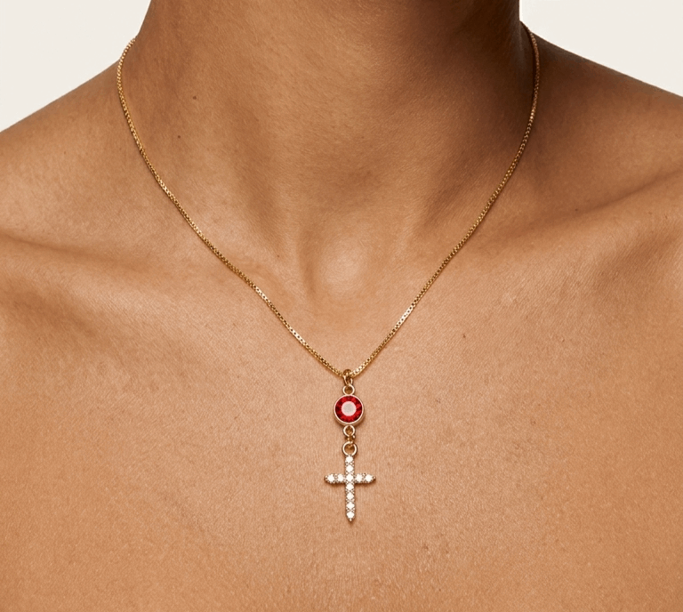 Gold-tone pendant necklace with red-orange round stone and cross charm